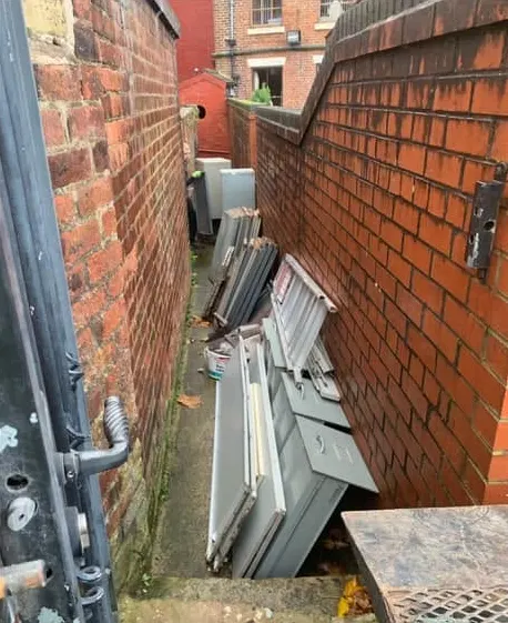 Before: old metal cabinets and panels stacked down a narrow alley