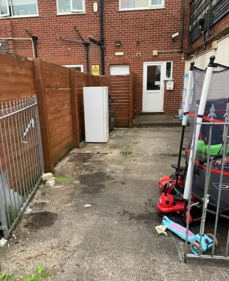 After: a clear back yard with the fridge and toys left in place
