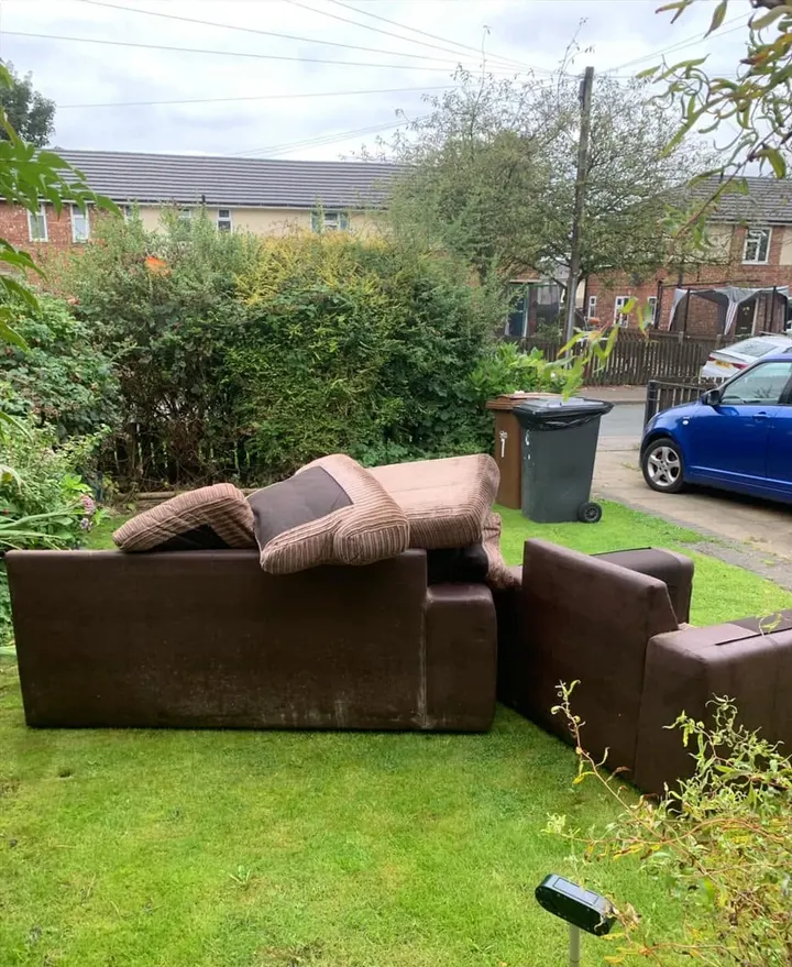 Before: two brown sofas and cushions dumped on a front lawn