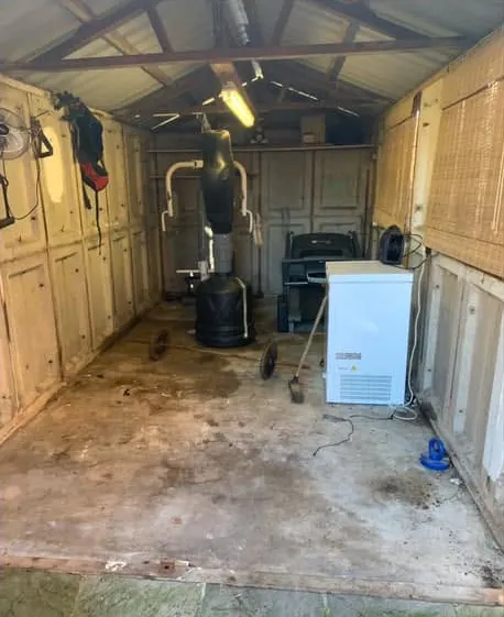 After: a cleared garage floor with the gym equipment and freezer left in place