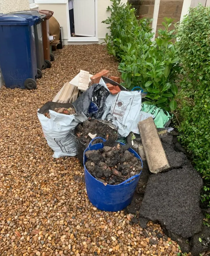Before: bags of rubble, bricks, tarmac and a kerb stone on a gravel path