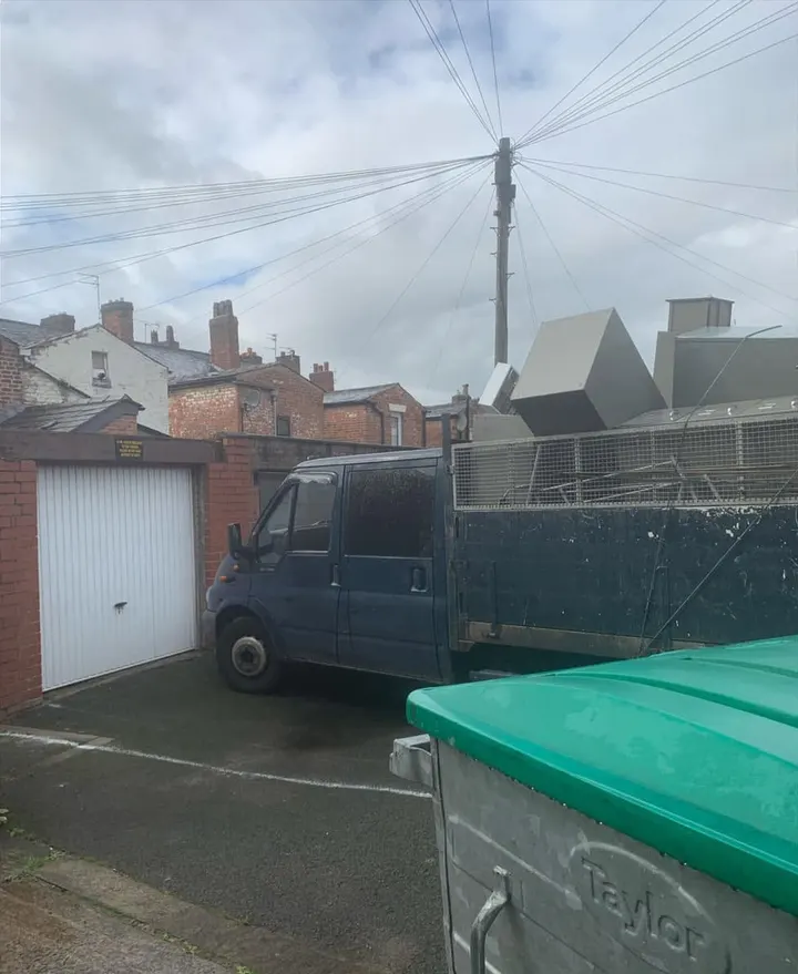 After: clear yard in front of a garage, with the cabinets loaded on the DG Rubbish Removal truck