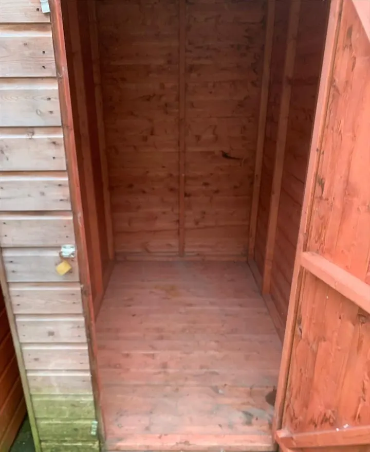 After: an empty timber shed with a bare floor