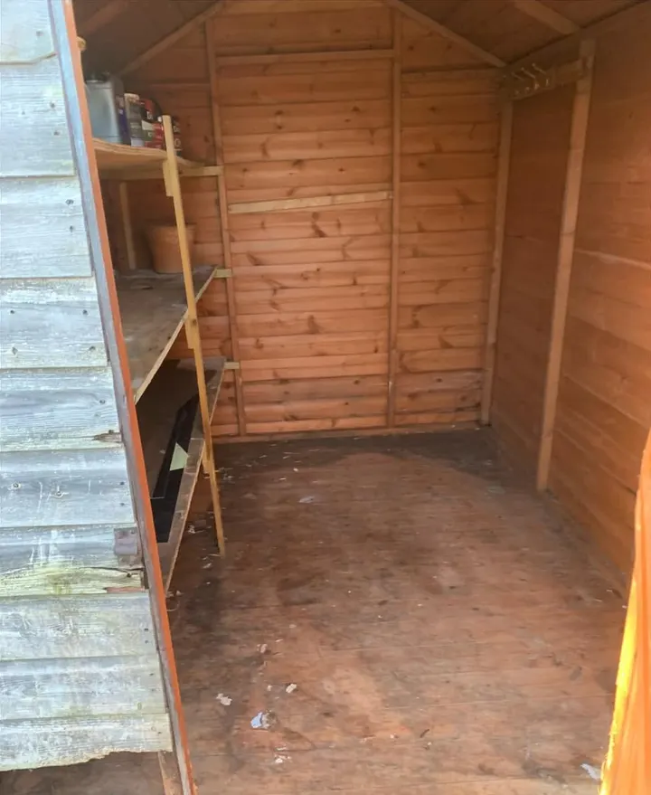 After: an empty timber shed with shelves