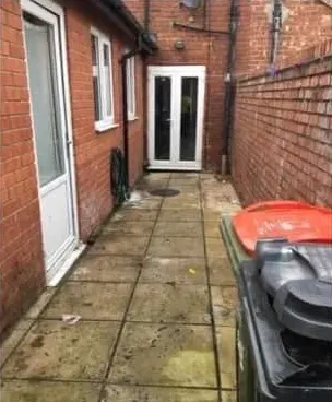 After: a clear, swept side passage between brick walls