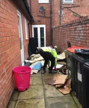 Before: our team member bagging carpet and cardboard in a side passage