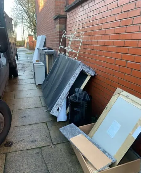 Before: a bed base, drawers, a mirror and a bin against a brick wall